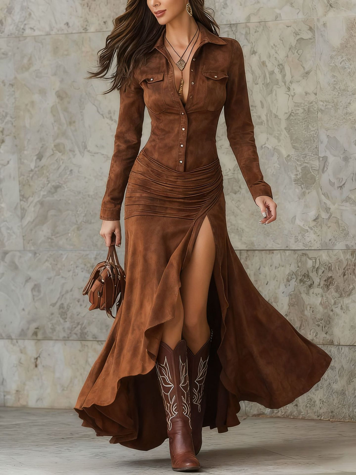 Woman wearing a long brown suede dress with a high slit, standing against a stone wall.