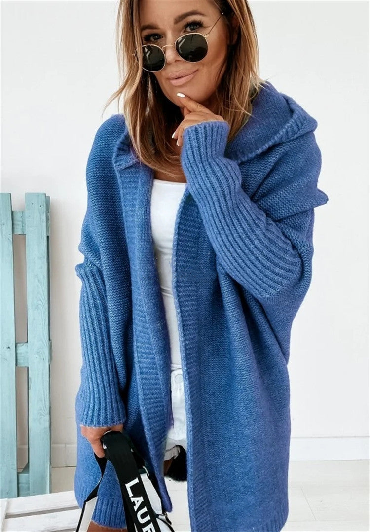 Woman wearing a blue cardigan with sunglasses on a white background