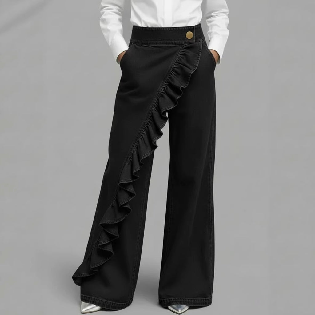 Person wearing wide-leg gray pants with a plain background