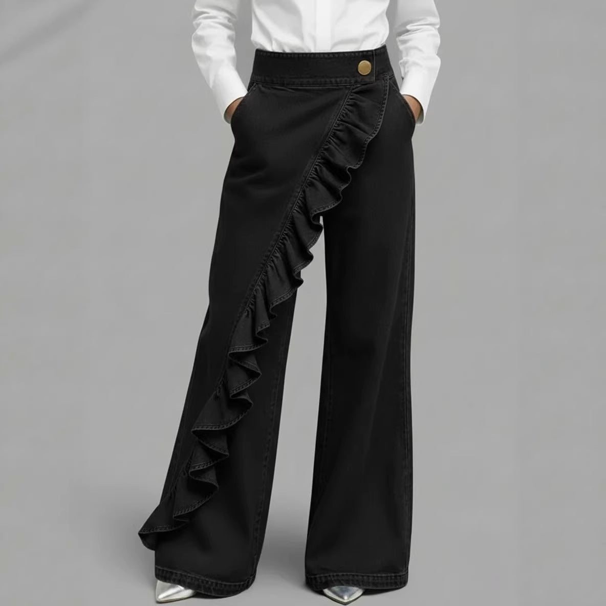 Person wearing wide-leg gray pants with a plain background