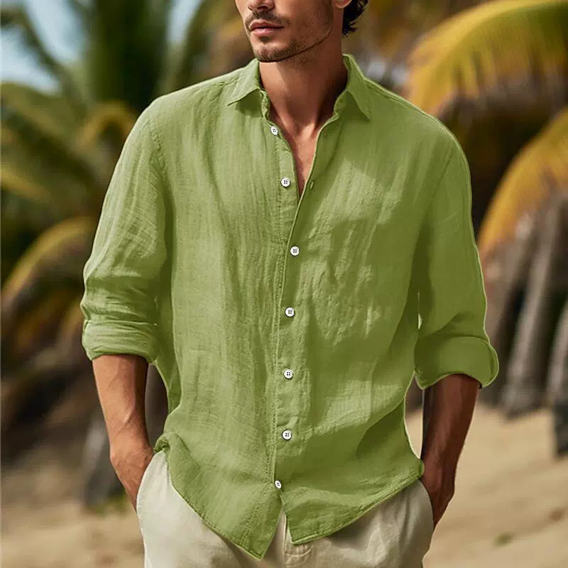 Man wearing a green shirt with palm trees in the background