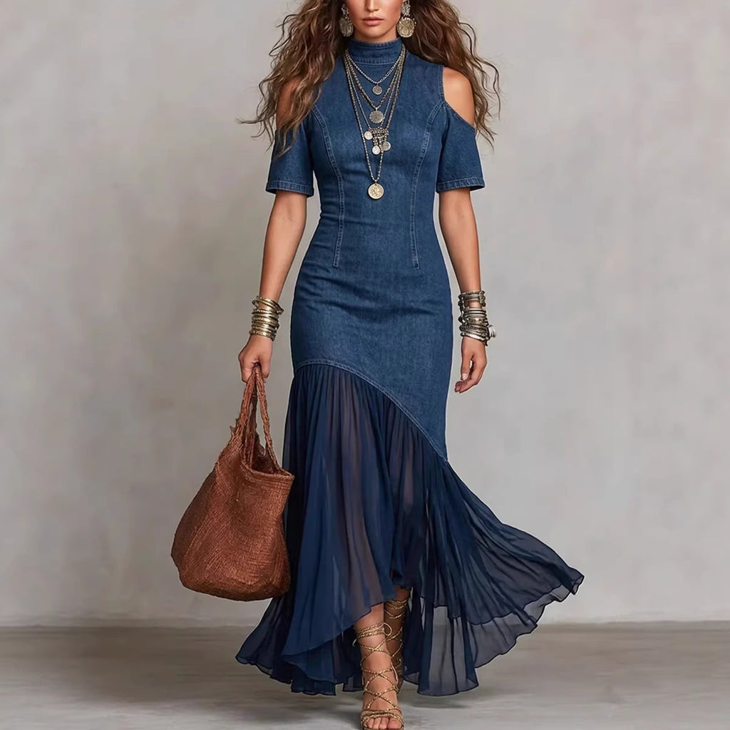 Woman wearing a blue dress with a brown handbag against a neutral background