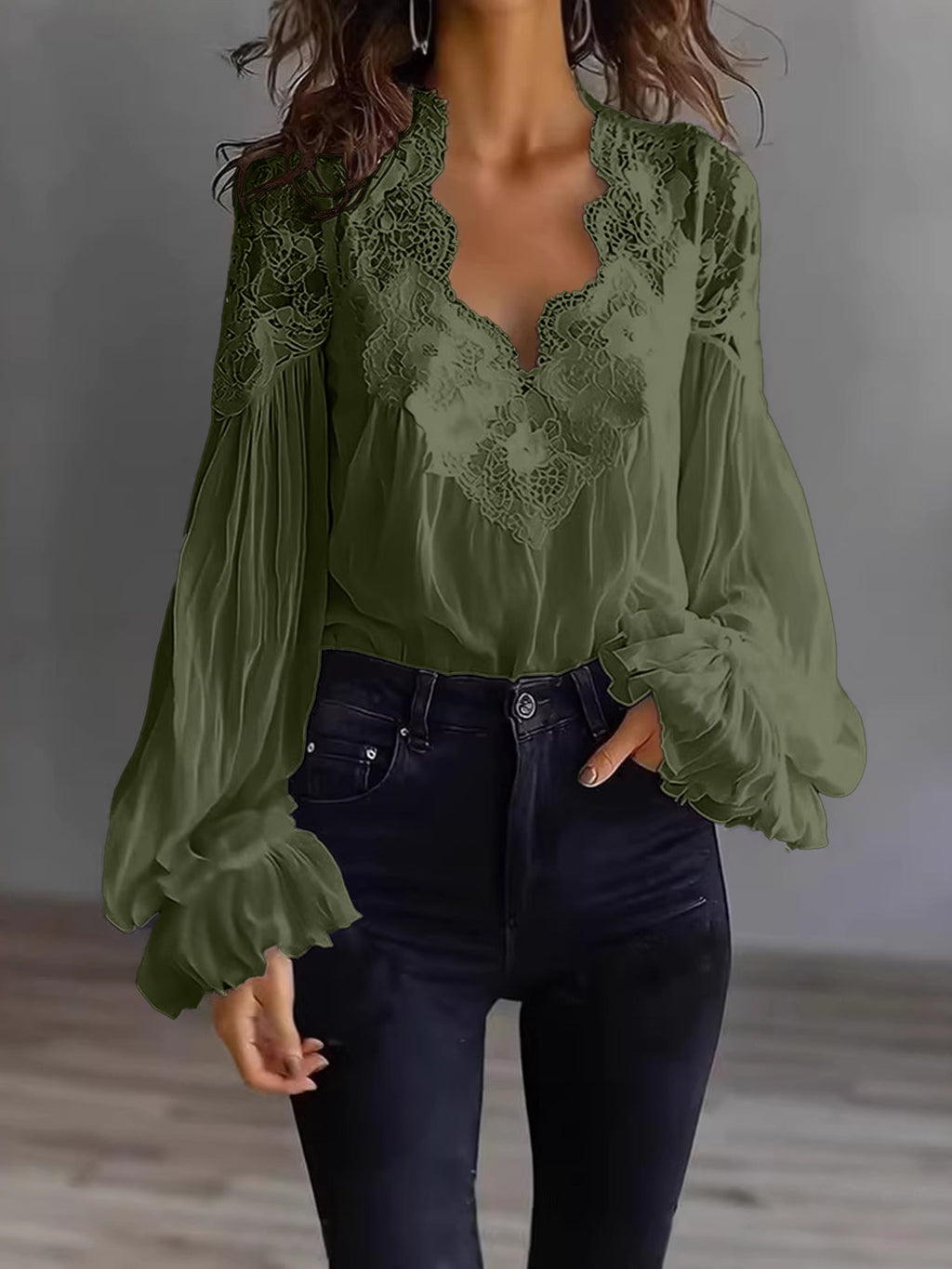 Green lace blouse with long sleeves worn by a person against a neutral background