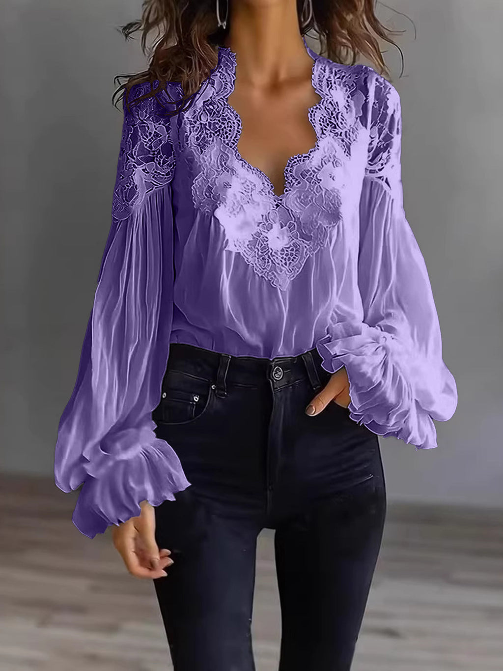 Purple lace blouse with long sleeves worn by a person against a neutral background