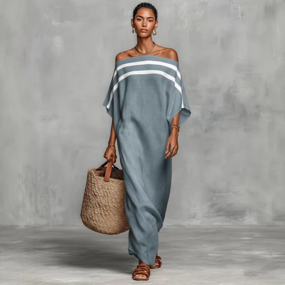 Woman wearing a gray off-shoulder dress with white stripes, holding a woven bag against a gray background.