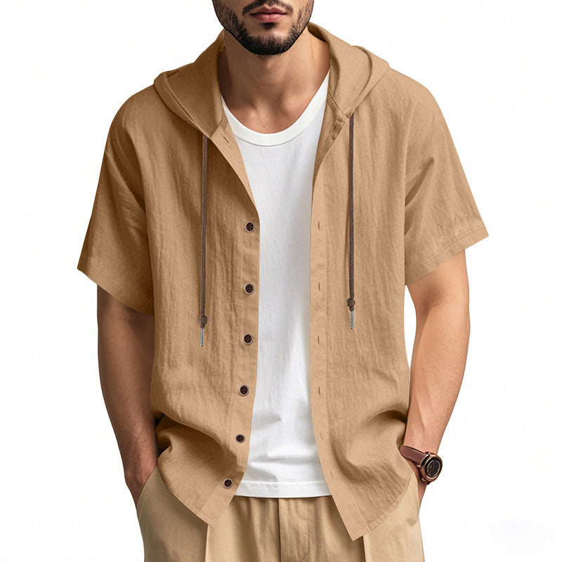 Man wearing a beige short-sleeve hooded shirt over a white t-shirt on a white background
