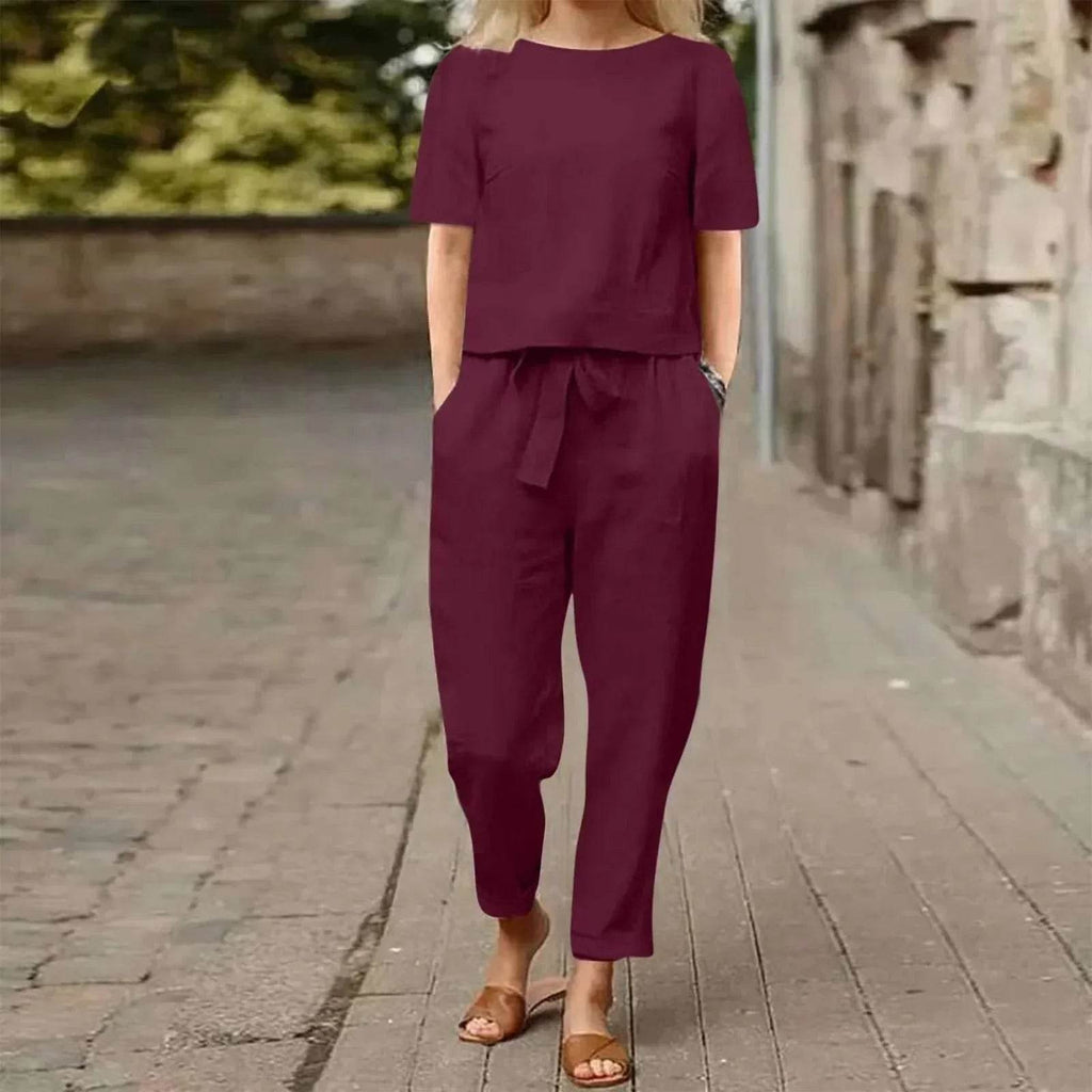 Woman wearing a burgundy matching linen set from ZA-Zola, walking outdoors in summer fashion.