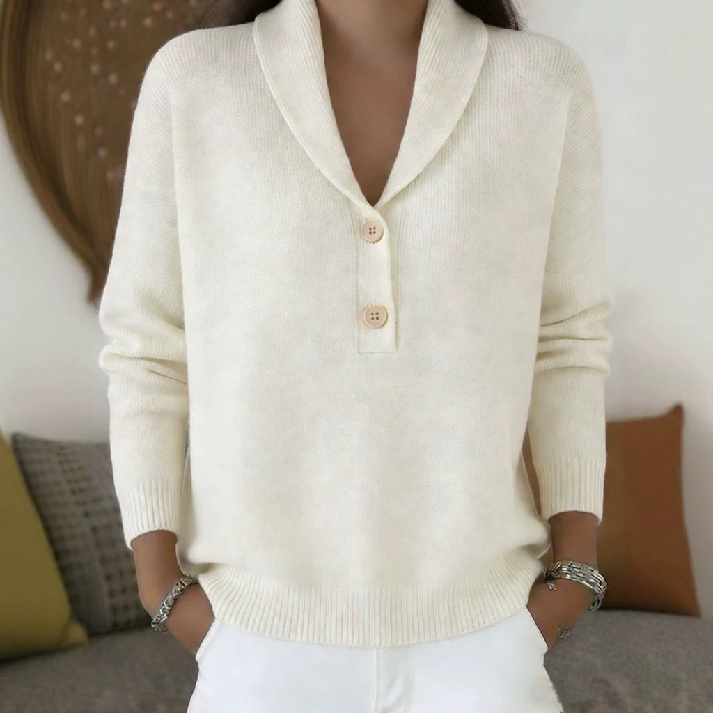 Person wearing a cream-colored sweater with buttons in a casual setting.