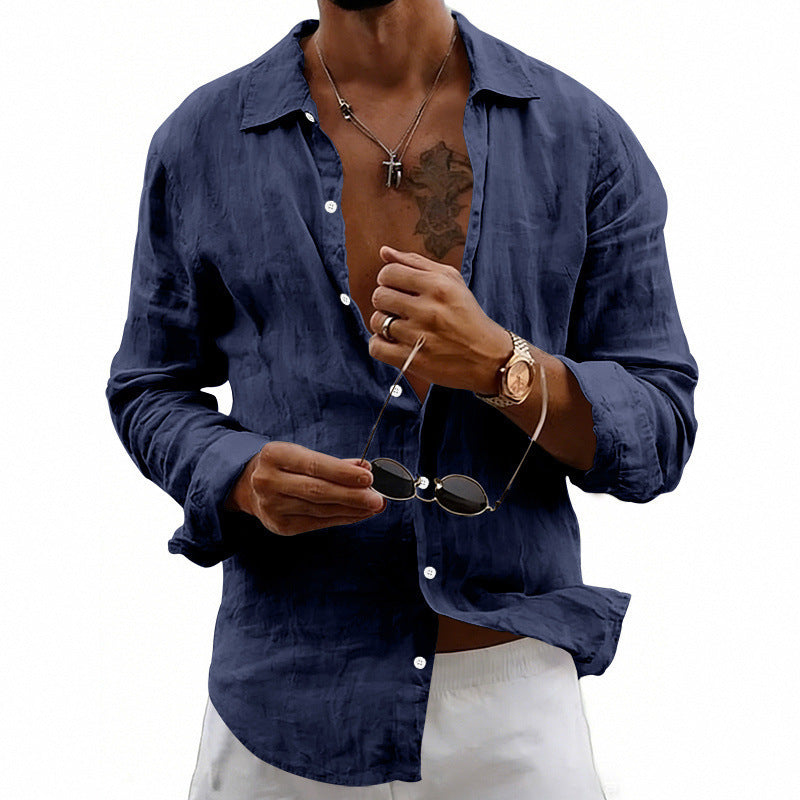 Man wearing a navy blue shirt holding sunglasses on a white background