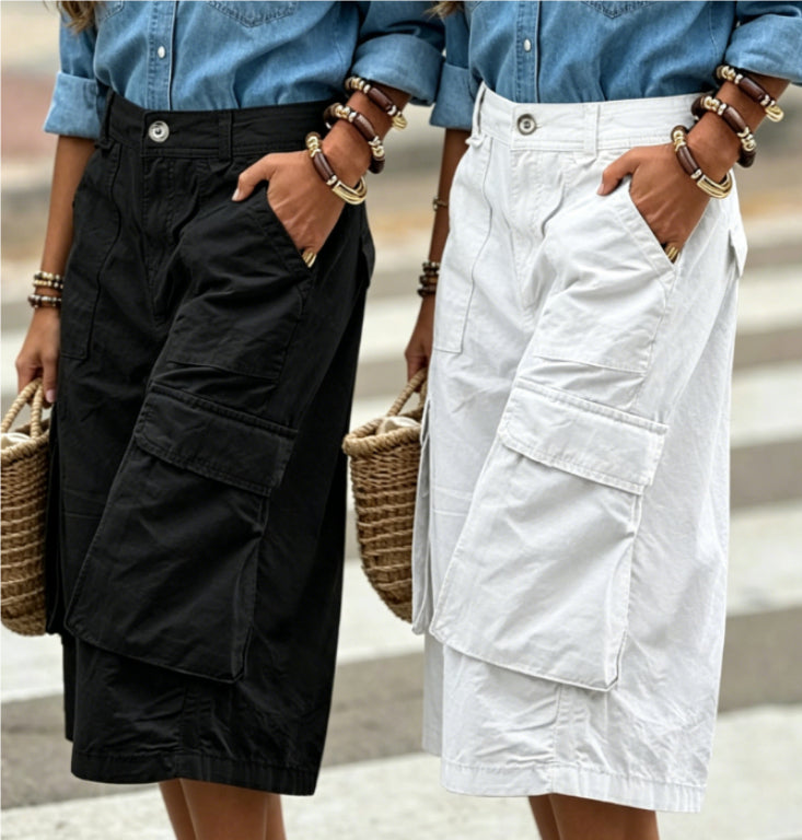 Two people wearing black and white cargo shorts with blue shirts, standing on a street.