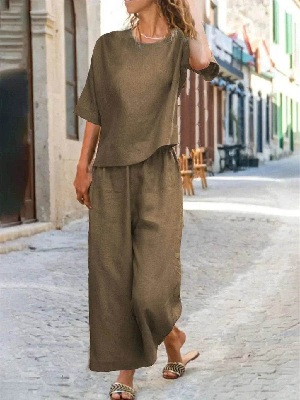 Woman in loose brown two-piece linen set from ZA-Zola, walking on a city street