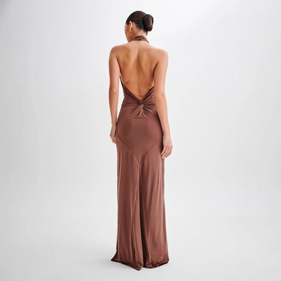 Woman wearing a brown evening gown with a backless design on a white background