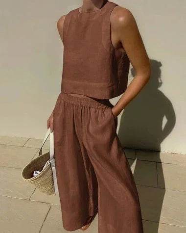 Woman in brown sleeveless crop top and wide-leg pants holding straw tote, ZA-Zola fashion