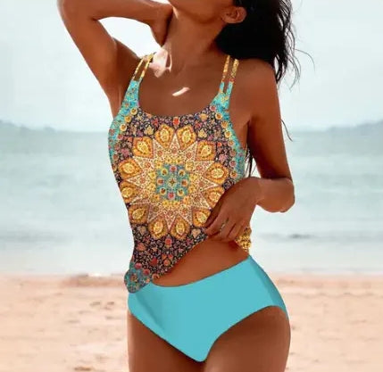 Woman wearing a colorful mandala-patterned swimsuit on a beach.