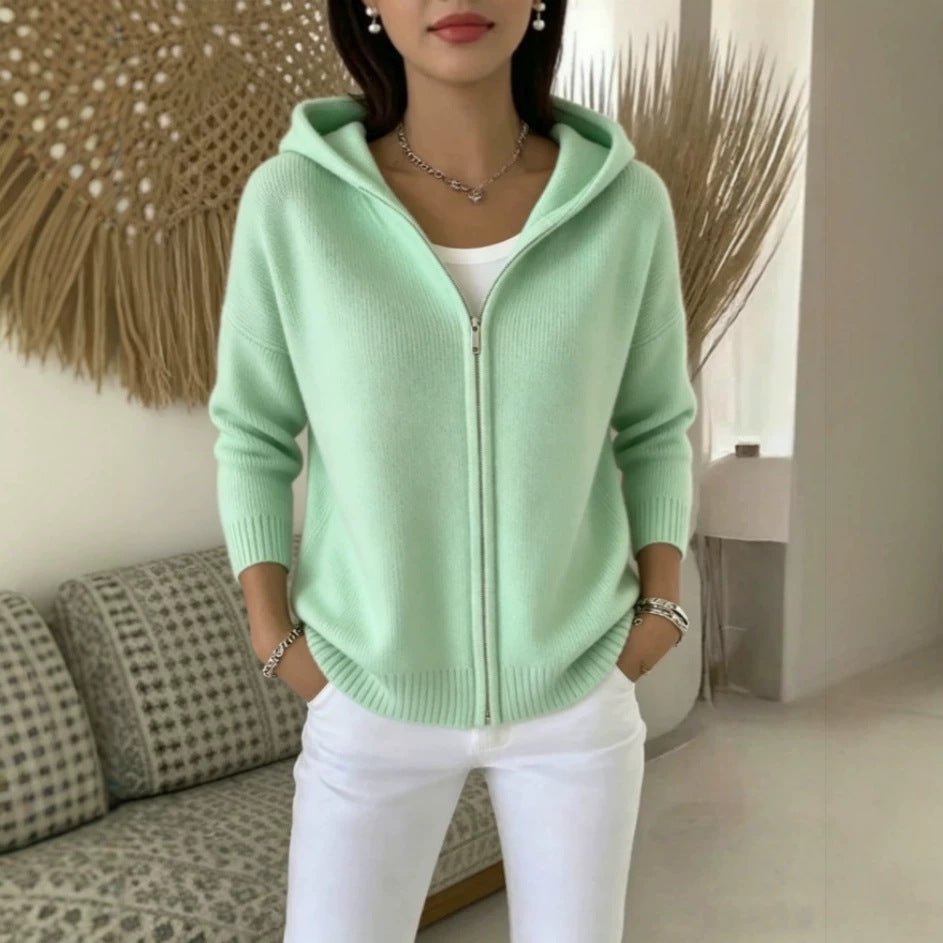 Person wearing a light green hoodie in a living room setting