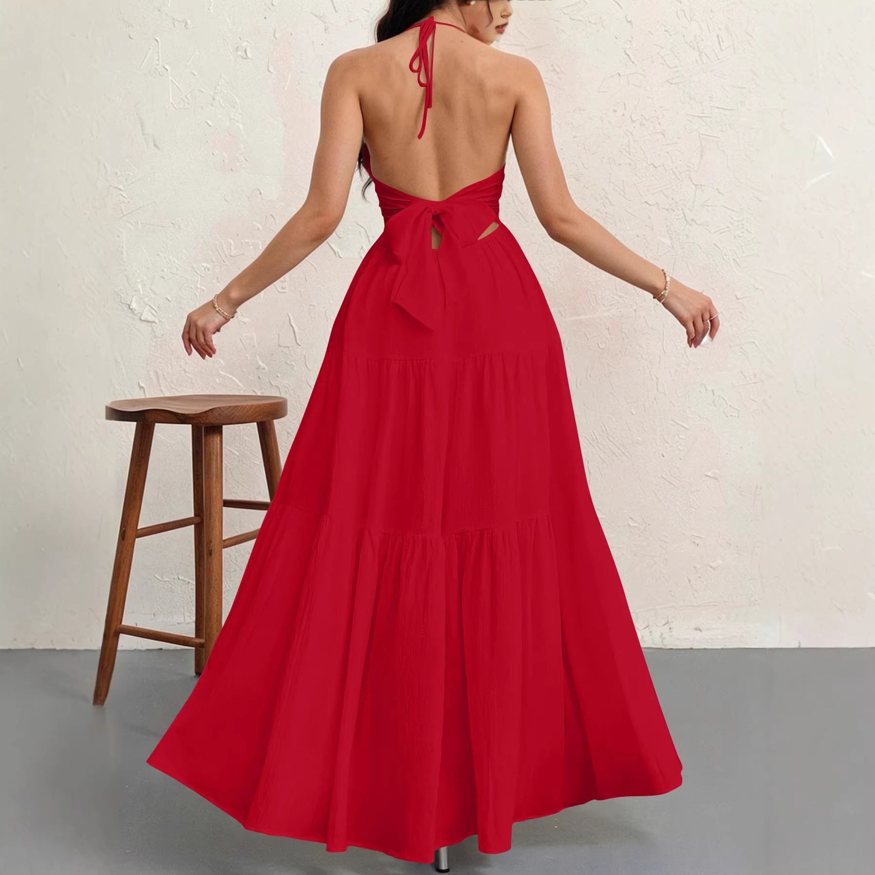 Woman wearing a red dress with a white brick wall background