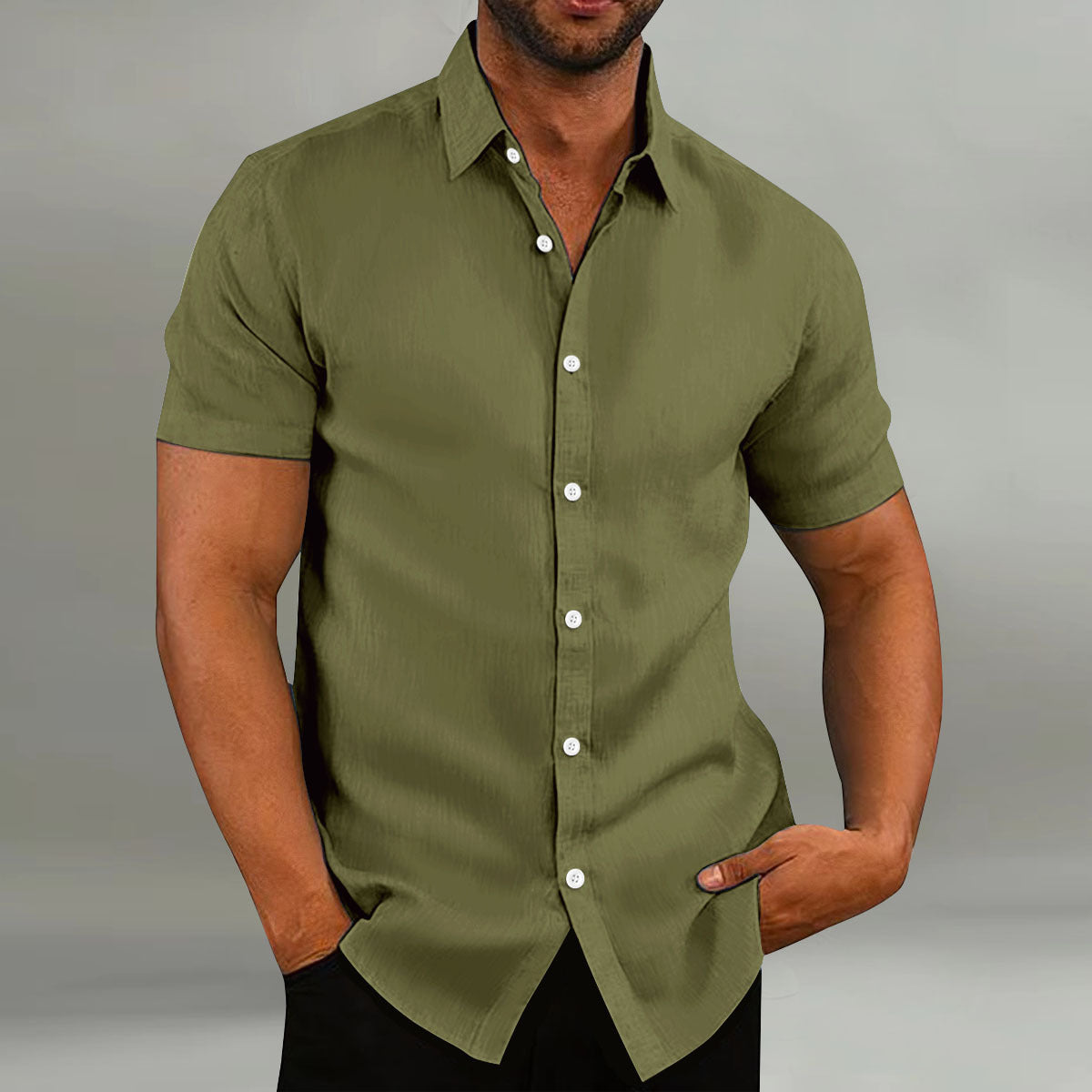 Man wearing a green short-sleeve shirt against a gray background