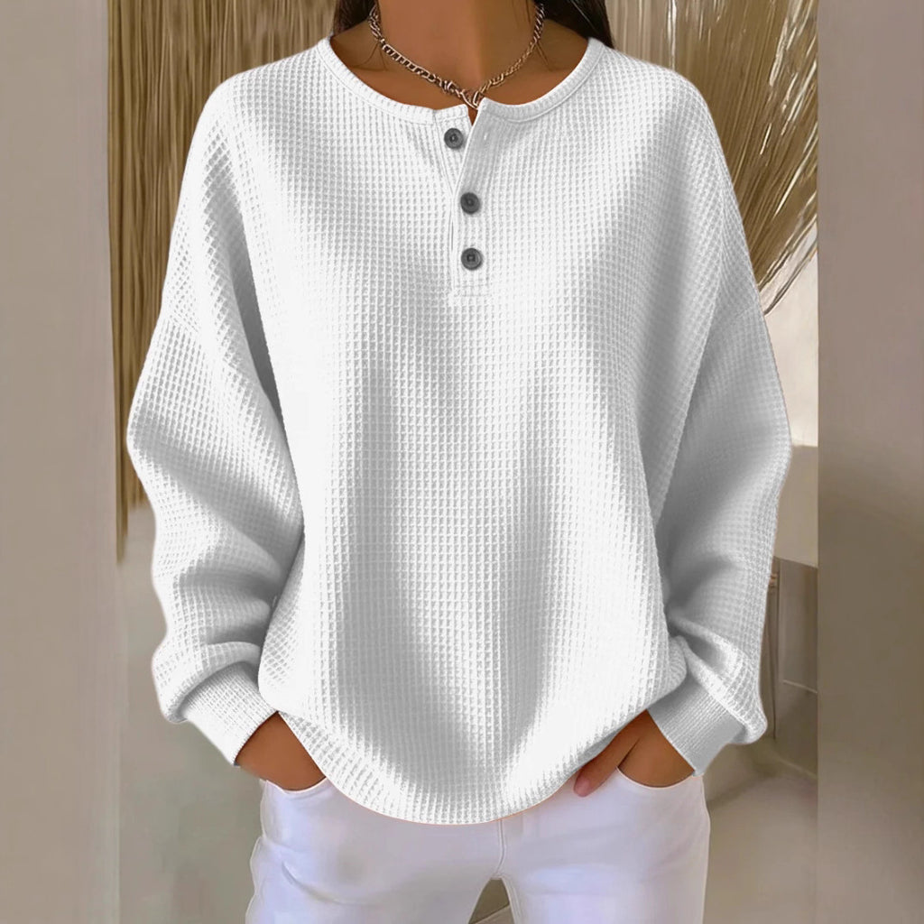 White textured long-sleeve shirt with buttons worn by a person against a neutral background