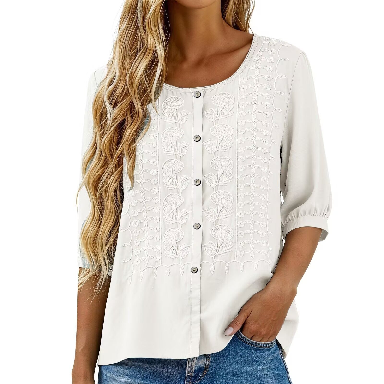 White blouse with floral embroidery worn by a person on a white background